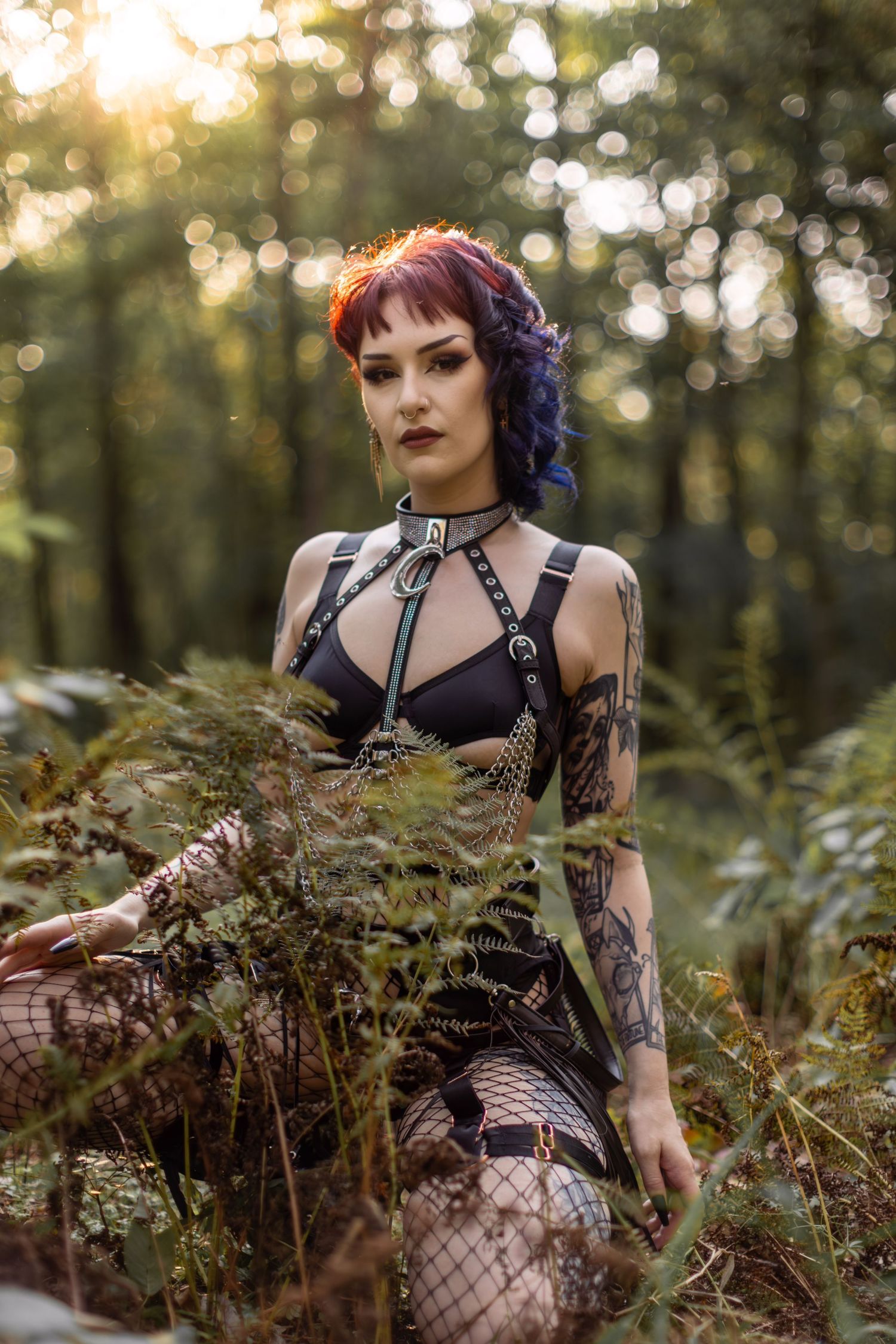 Gothic fashion shoot in wild ferns with late afternoon sunlight filtering through trees.