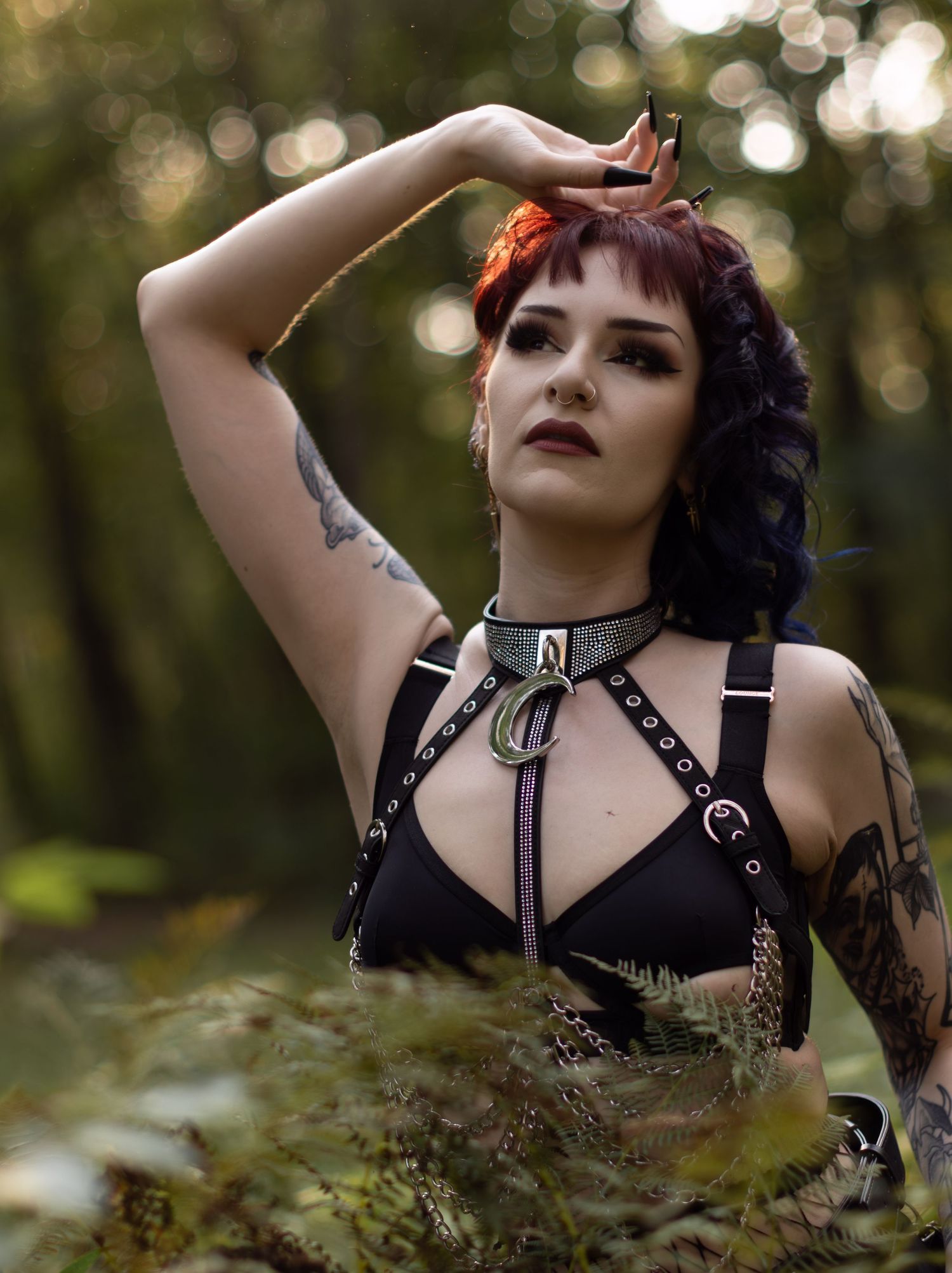 Dramatic forest photoshoot featuring alternative style and black harness accessories.