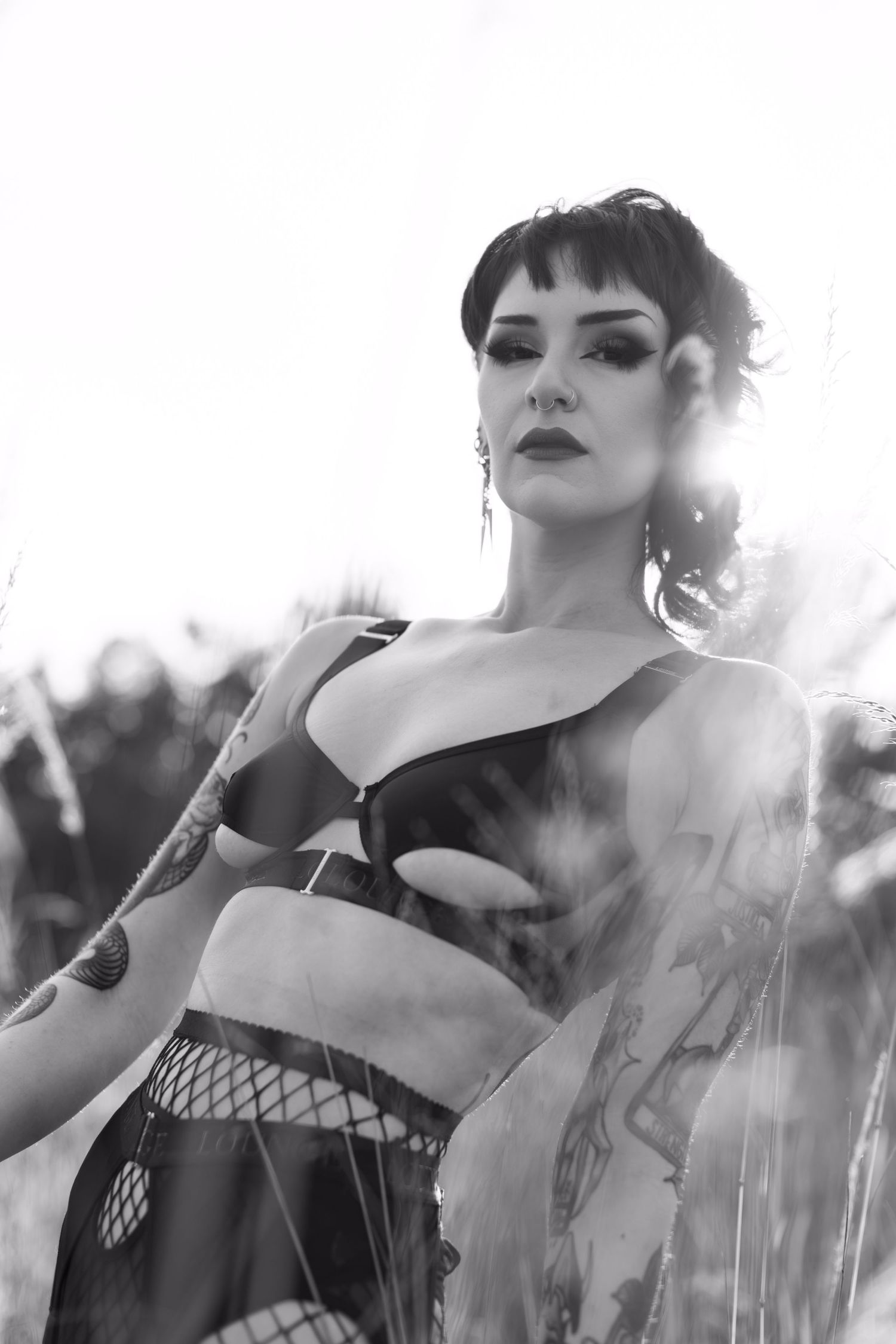 Dramatic black and white portrait of person in alternative fashion against bright sunlight.