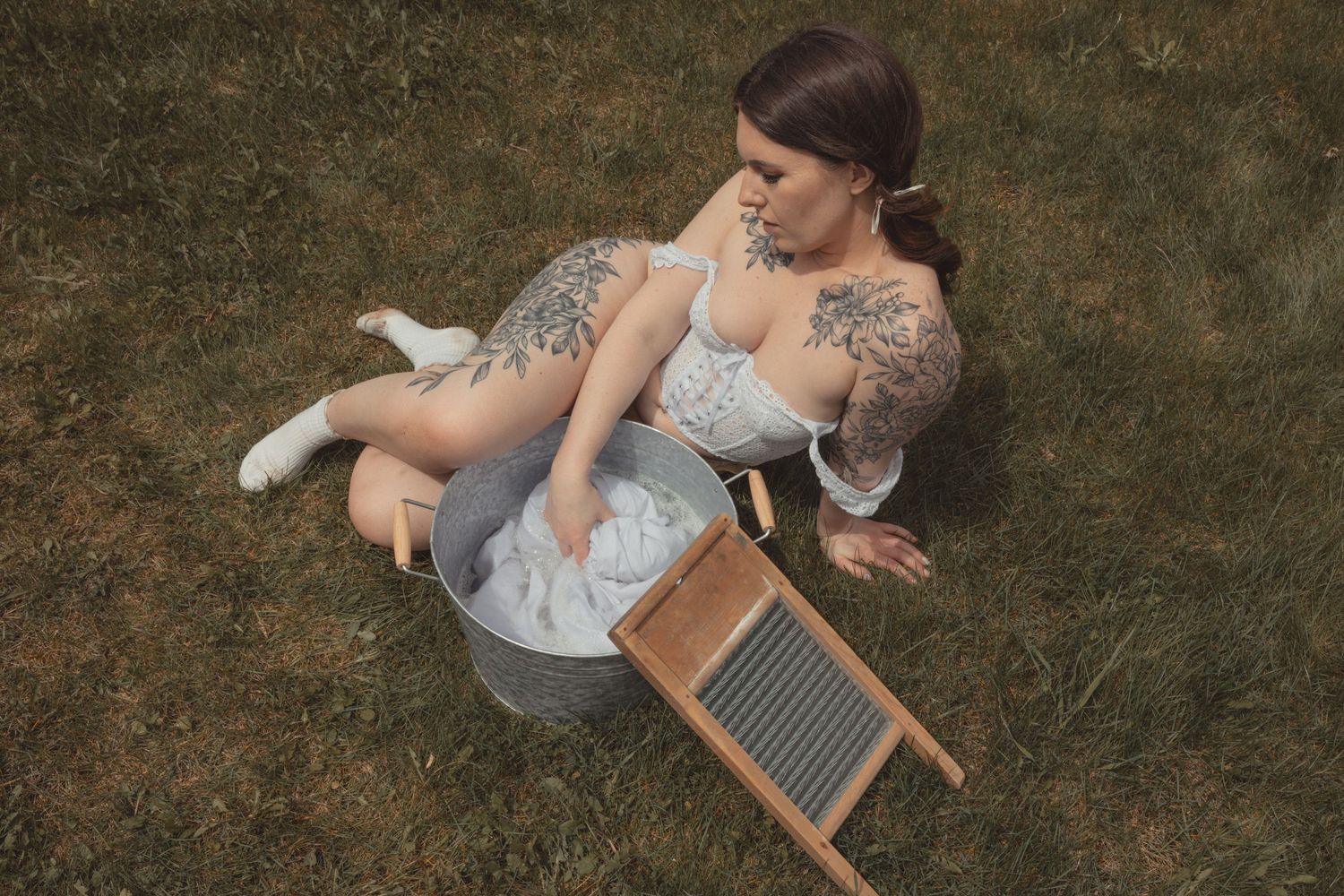 Vintage-inspired scene of hand washing laundry with metal basin and washboard.