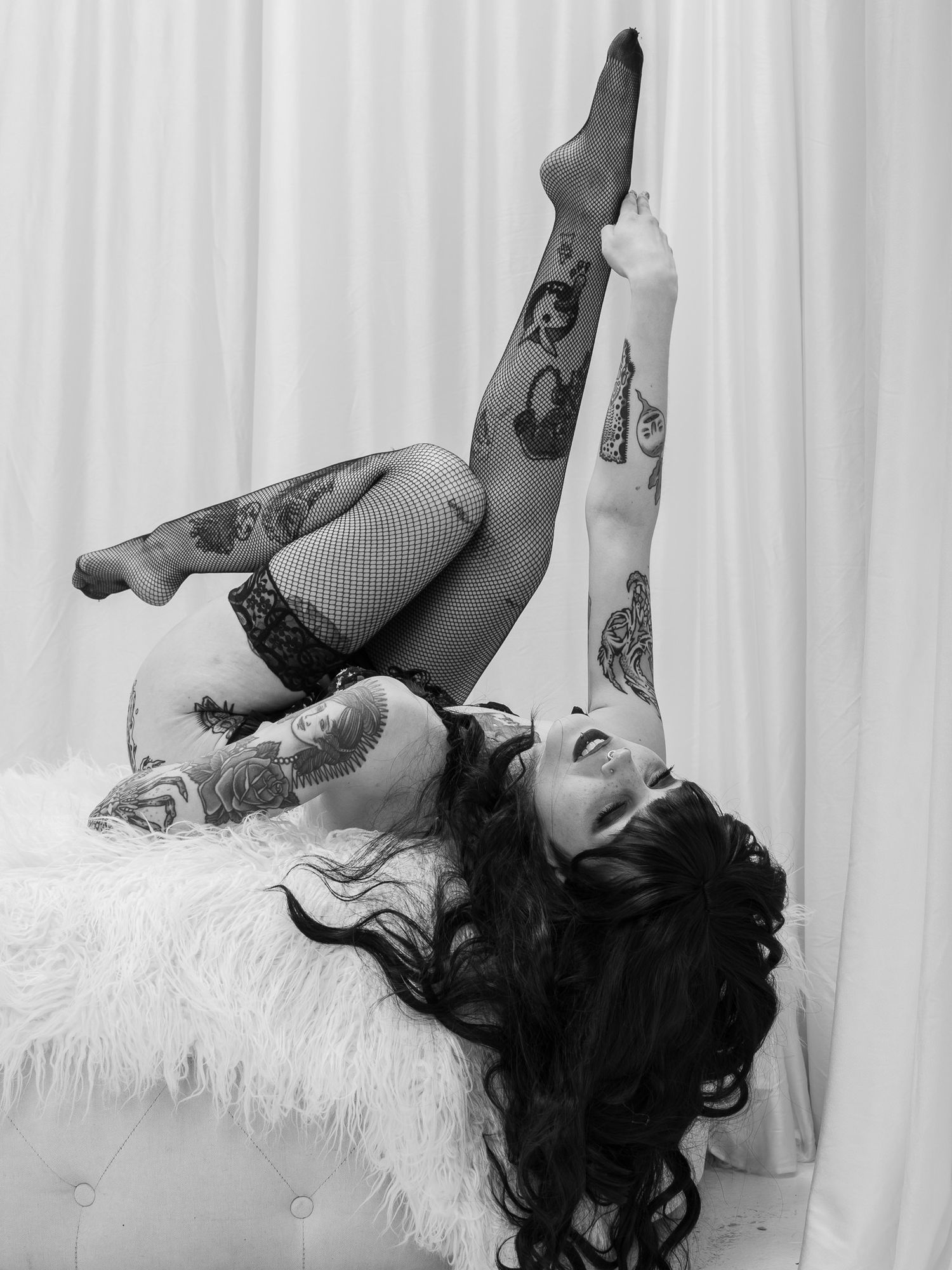 A series of black and white boudoir photos showing a woman in lingerie posing on white bedding.