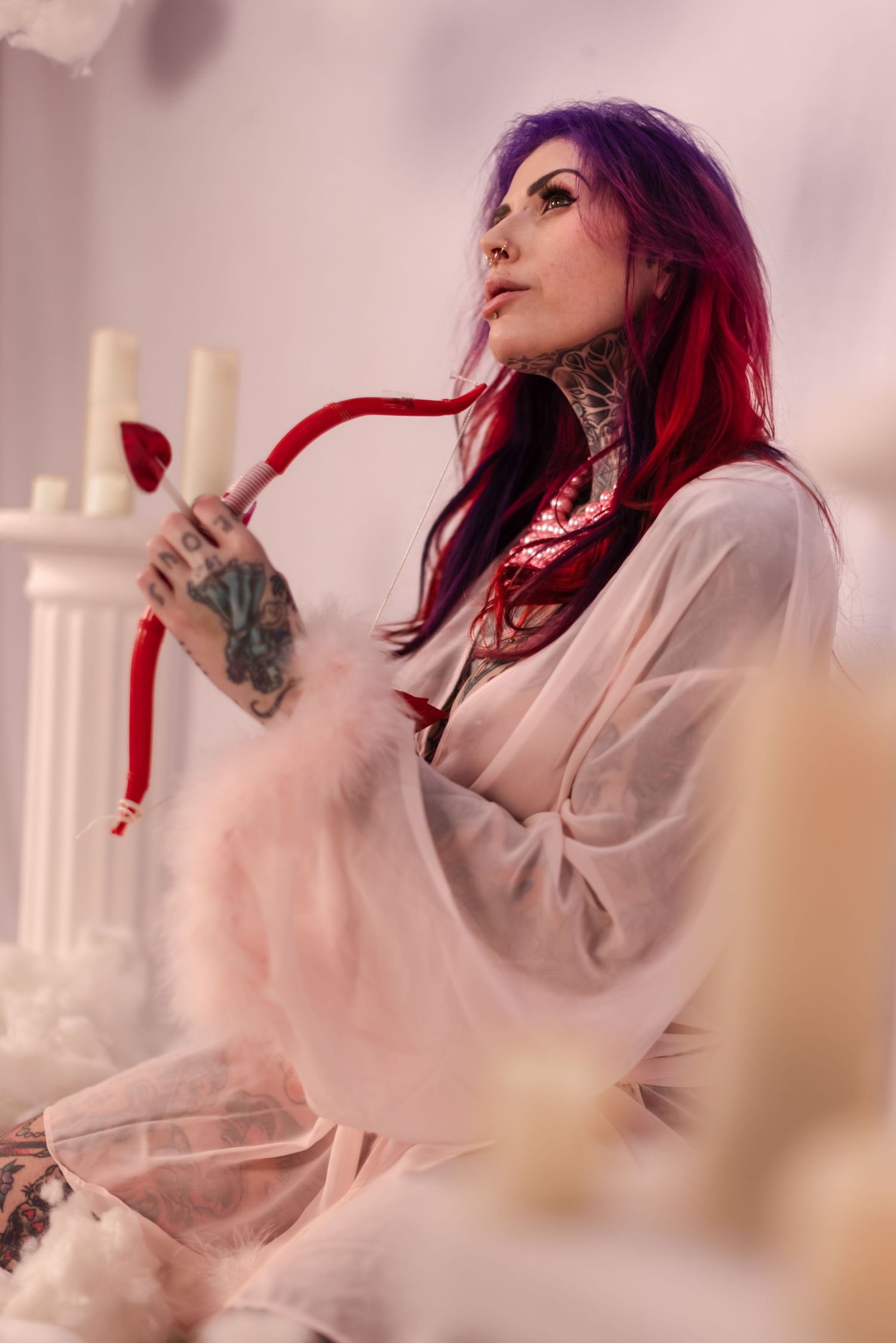 Artistic portrait series showing someone in white clothing with vibrant red hair against a soft pink background.
