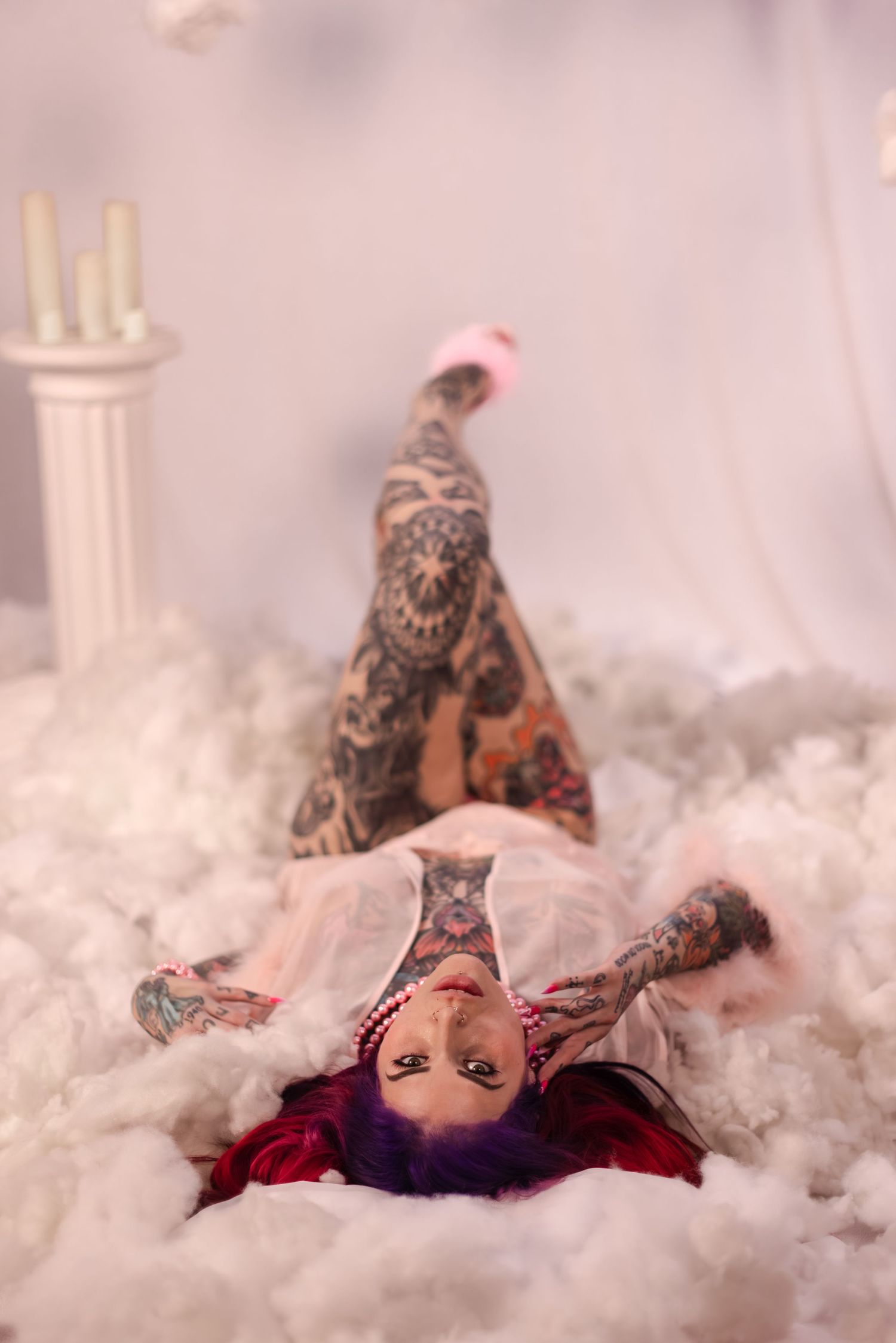 Dreamy portrait scene with soft pink lighting and white misty backdrop.