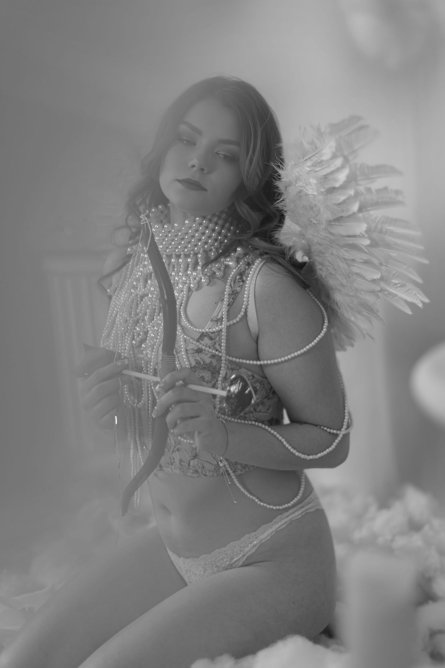 Black and white artistic boudoir photograph series featuring a model in elegant pearls and beaded accessories.