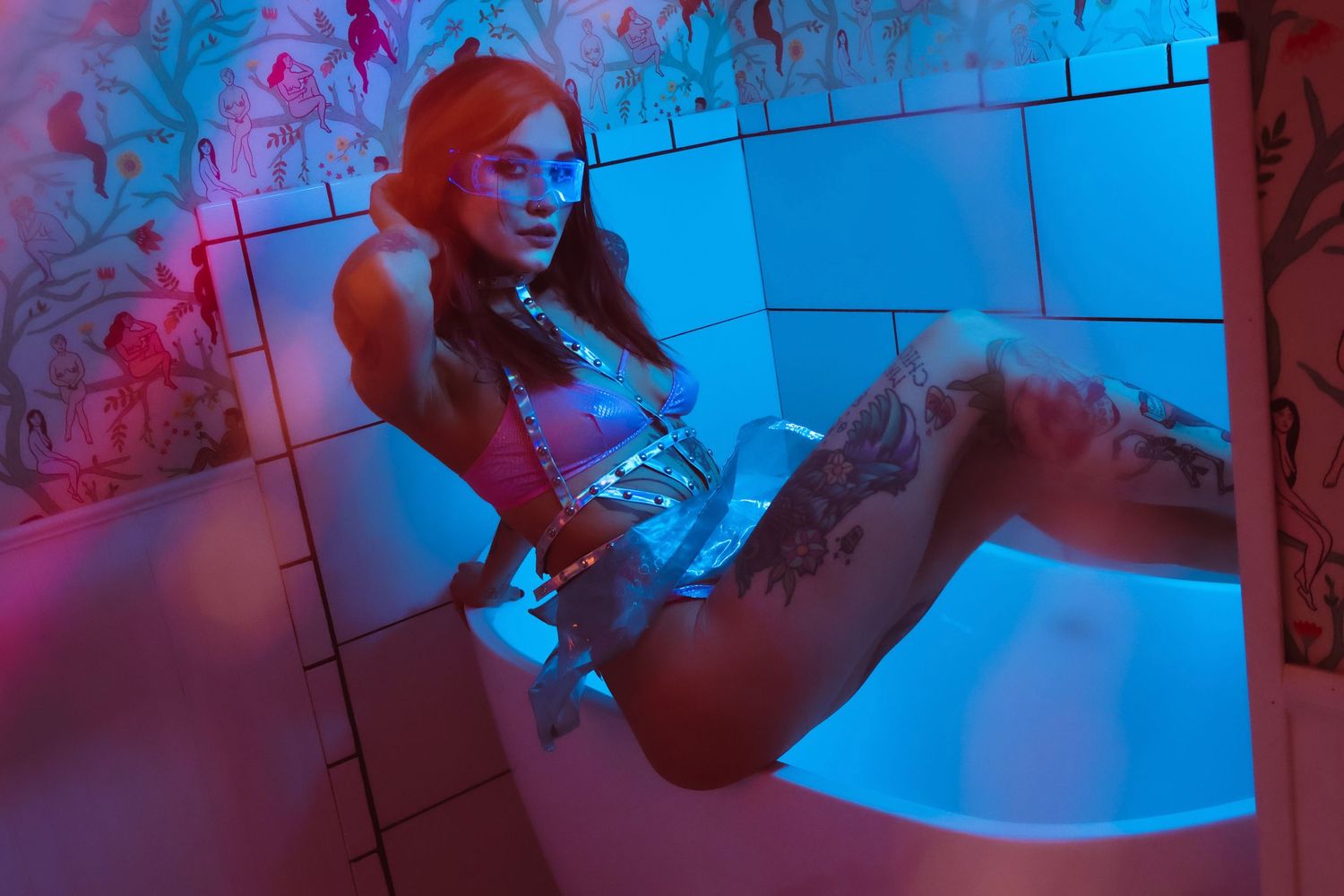 Artistic photoshoot with blue and pink lighting creating a moody atmospheric effect.