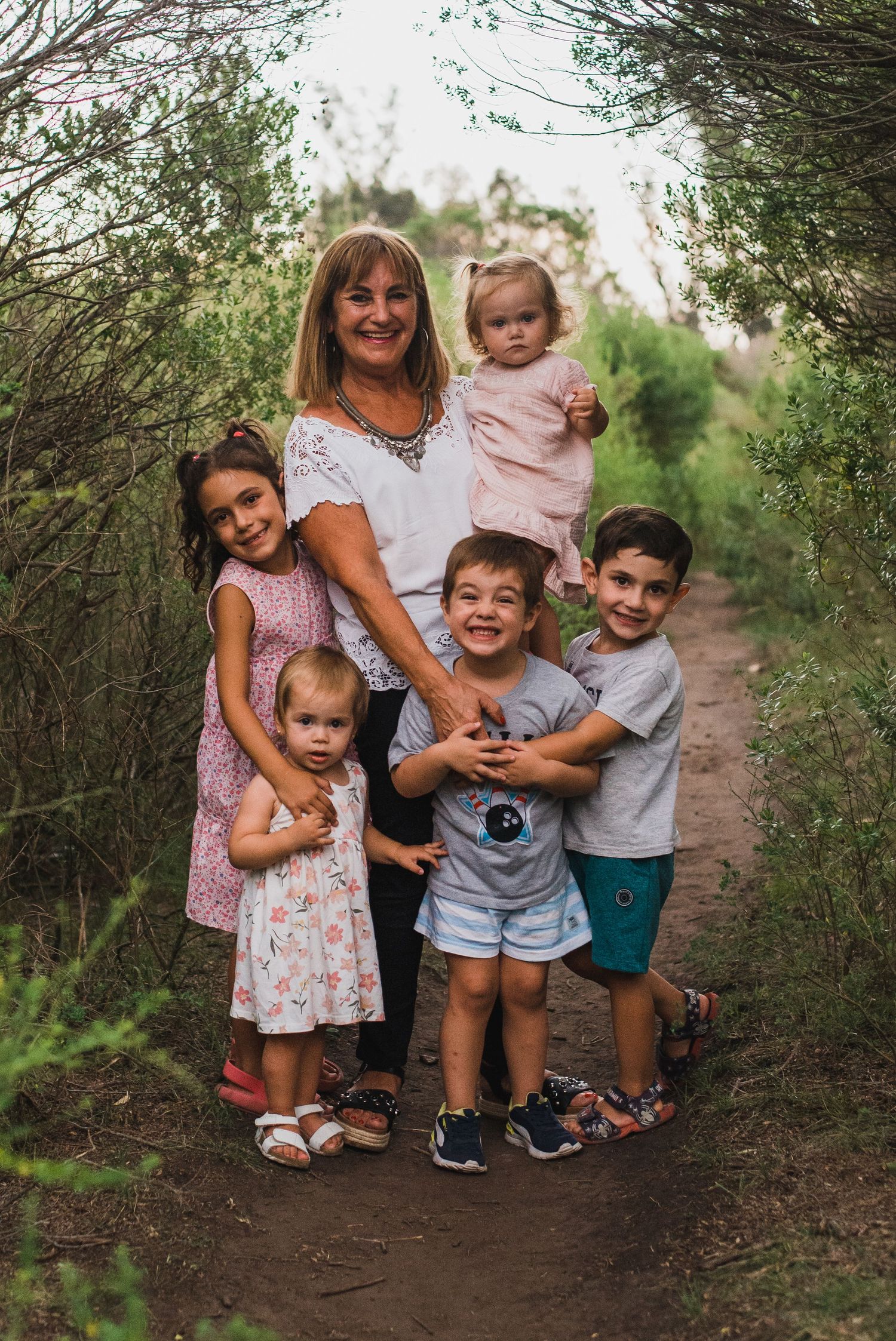 Abuela rodeada de sus 5 nietos en la naturaleza