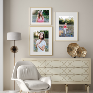 Stylish room setting with three framed portraits and decorative gold accents.