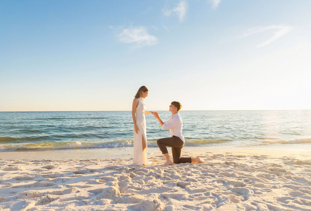 Beachside proposal at sunset with ocean waves in background.