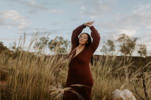 Woman standing on rocks posing while looking over her shoulder at Lake Moondarra, Mount Isa
