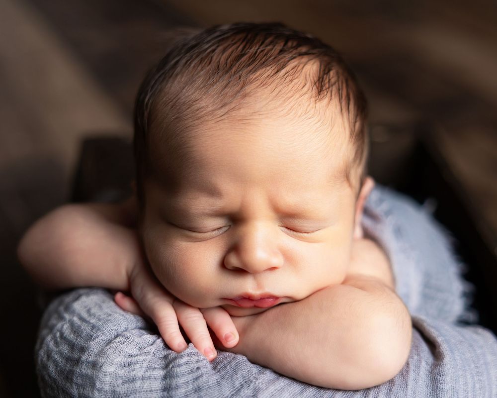 Close up macro shots of a sleeping newborn baby in soft natural lighting.