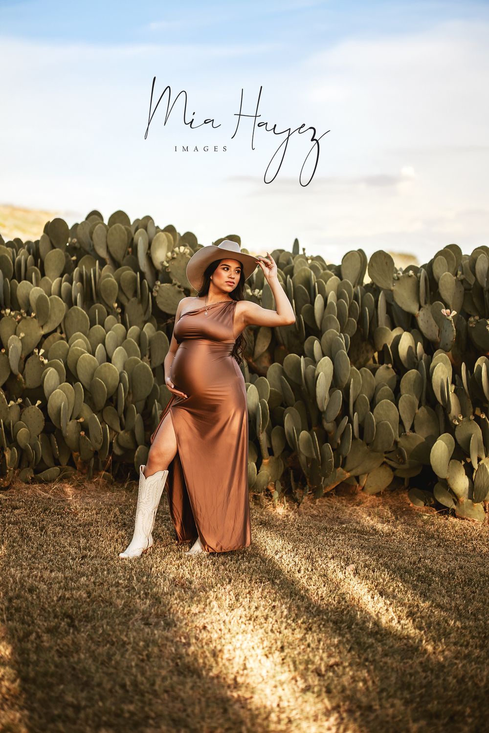 Maternity photo session at sunset against backdrop of cactus plants.