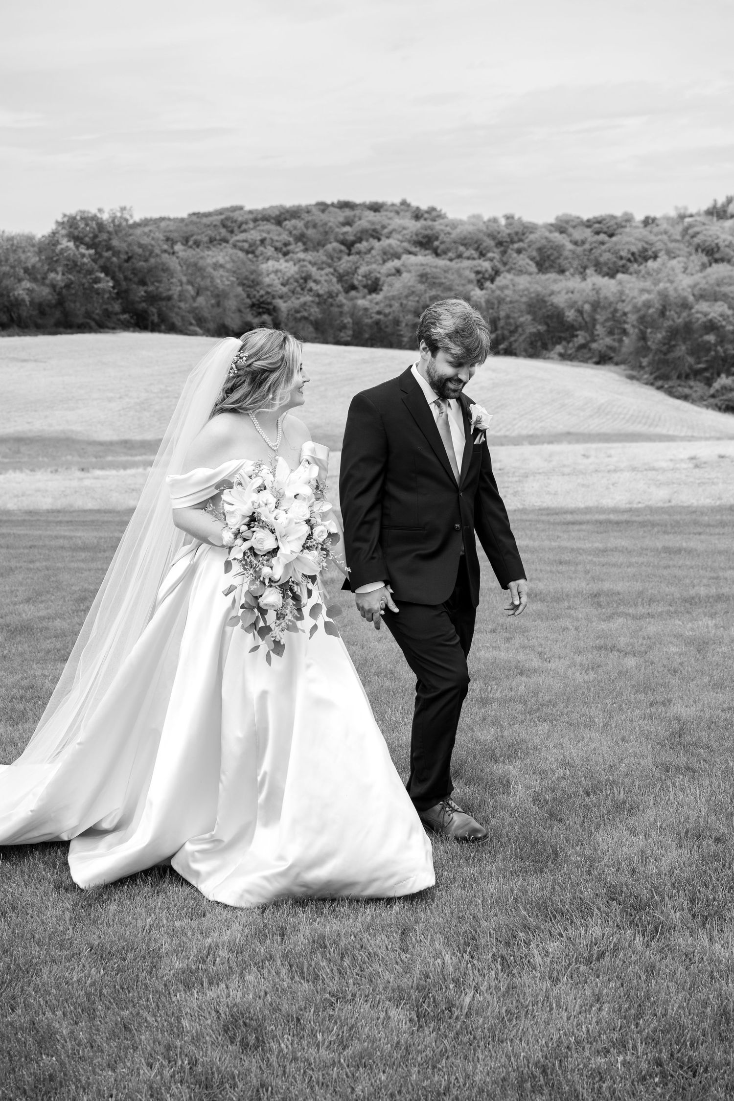 Wedding cake moment captured in black and white under outdoor tent.
