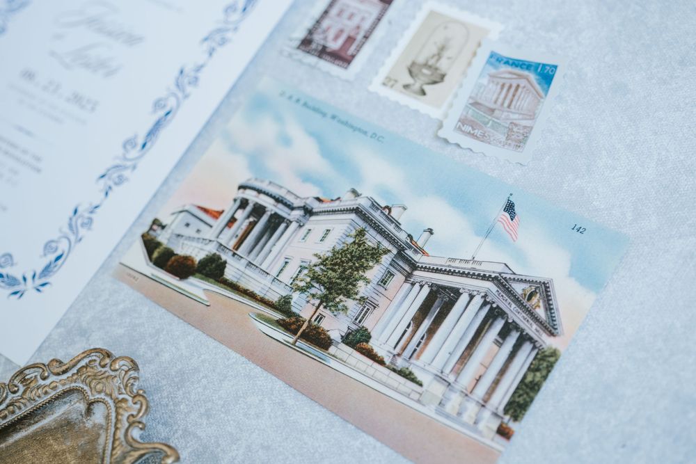 Vintage postcard showing a grand neoclassical building with white columns and architectural details against a blue sky.