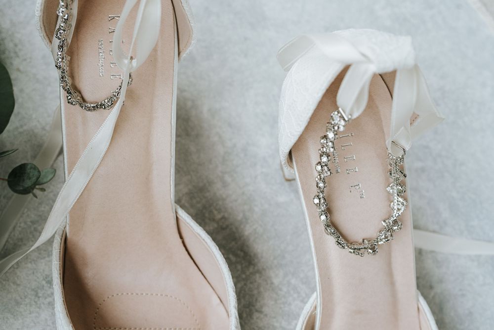 Elegant bridal jewelry and accessories including pearl necklaces, earrings and hair pieces laid out on a light surface.
