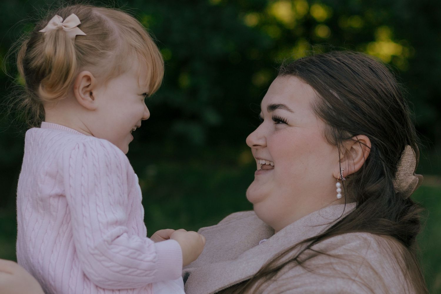 A tender moment between parent and child outdoors in natural lighting.