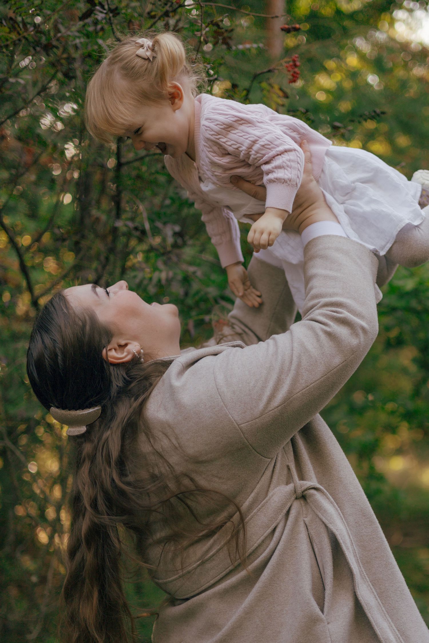 A joyful moment captured between parent and child playing in a natural outdoor setting.