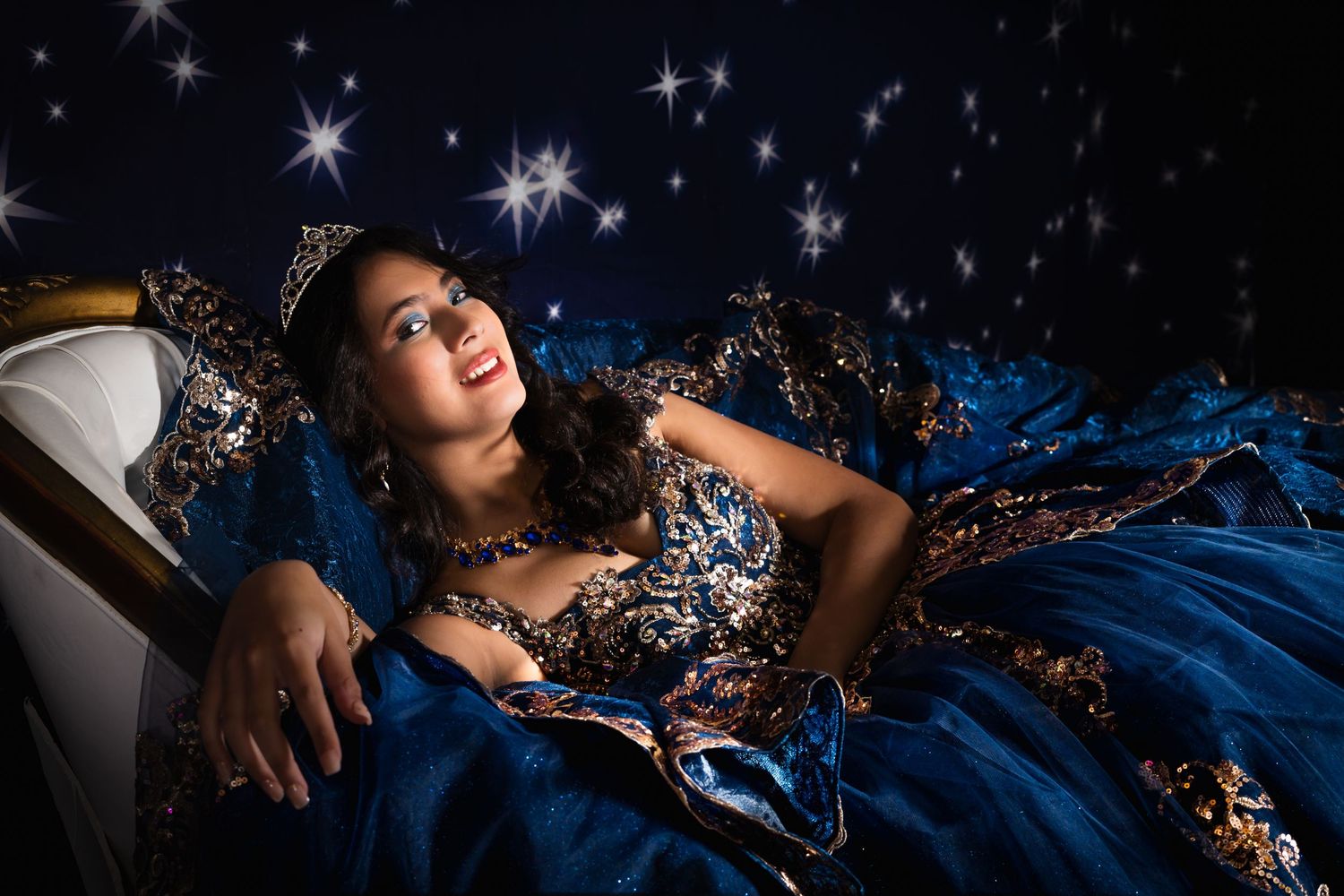 Elegant evening photoshoot with sparkly stars and dark blue formal gown.