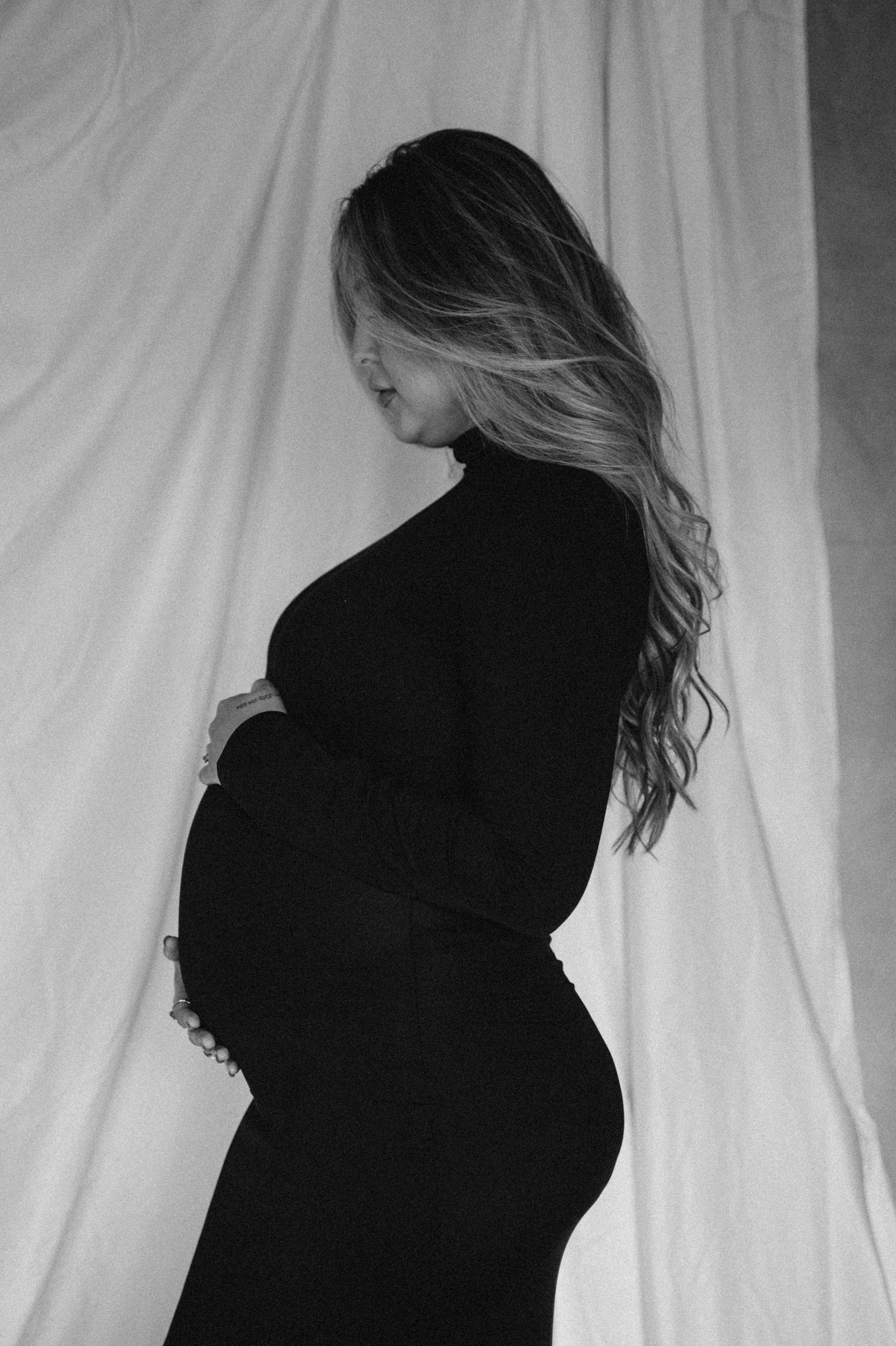 Silhouette profile shots of an expectant mother against a white backdrop showing pregnancy progression.