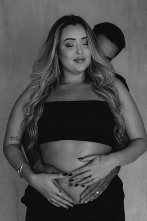 Intimate maternity portrait in black and white showing expectant couple.