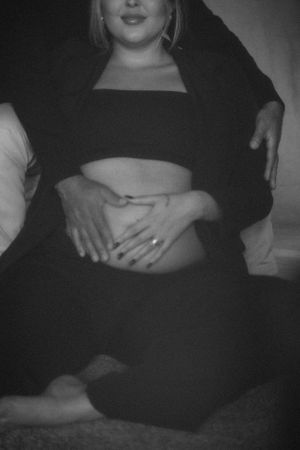 Black and white maternity photo showing loving embrace and baby bump.