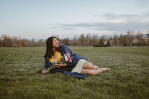 A series of artistic portraits showing a person lying in a grassy field at sunset creating dreamy compositions.