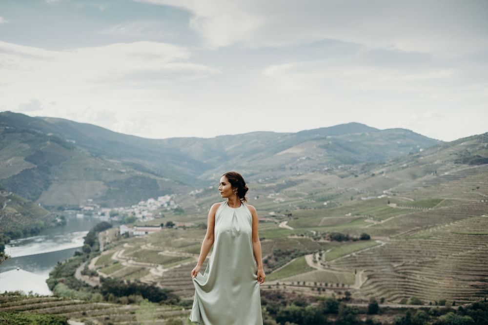 Cátia overlooks scenic Douro Valley vineyards and river landscape in Portugal during a couple shoot in Quinta de Ventozelo