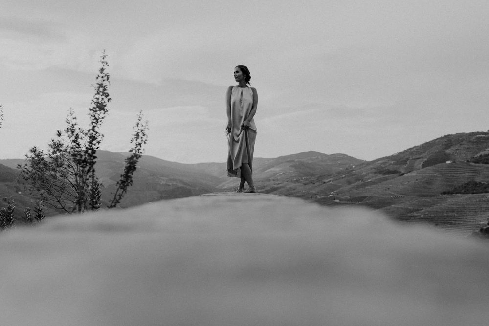 Cátia overlooks scenic Douro Valley vineyards and river landscape in Portugal during a couple shoot in Quinta de Ventozelo