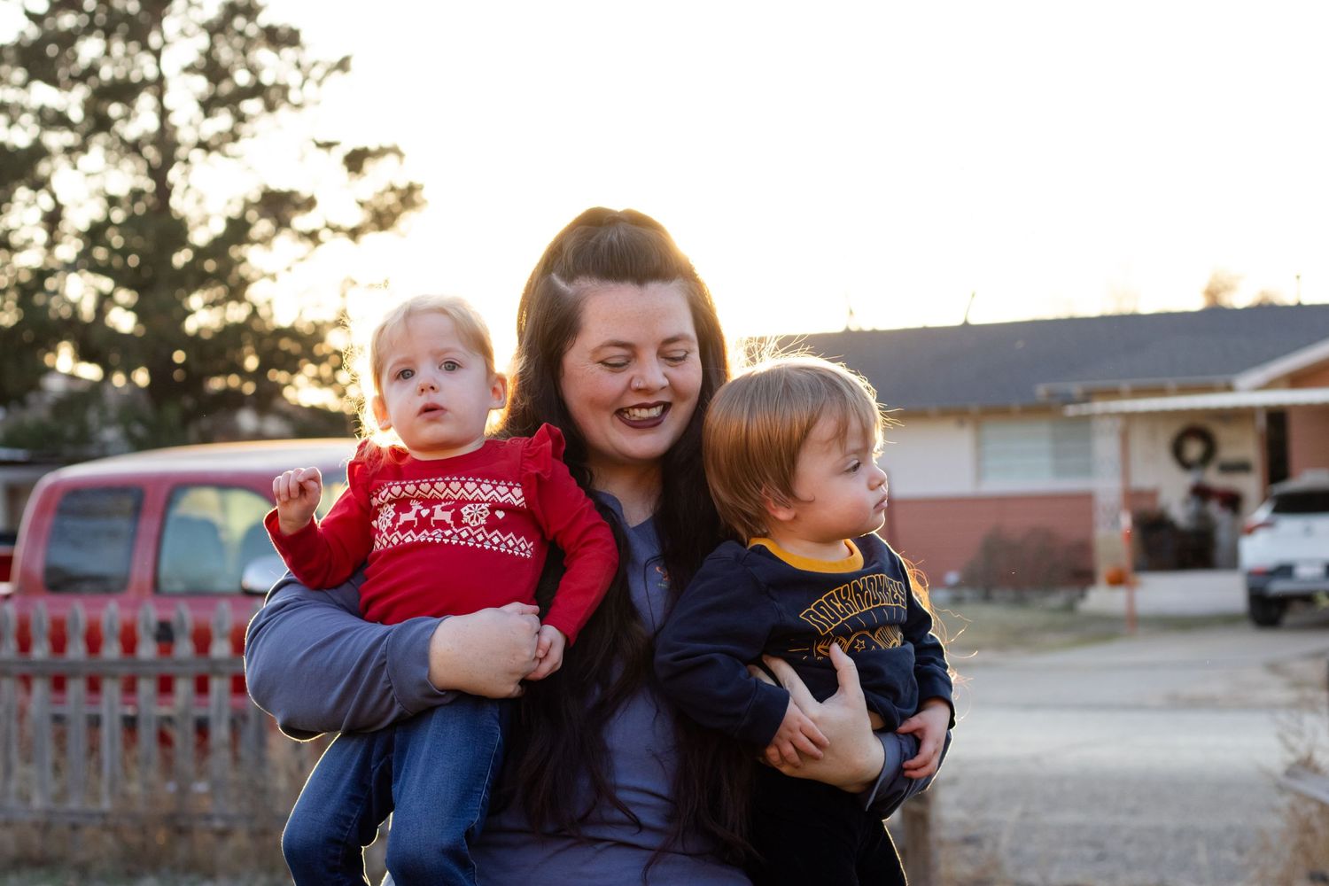 A happy mother holds her twin babies at golden hour in Tulia, Tx