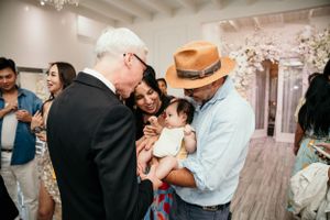 A candid moment of love and connection between family members at an indoor gathering with cherry blossoms in the background.