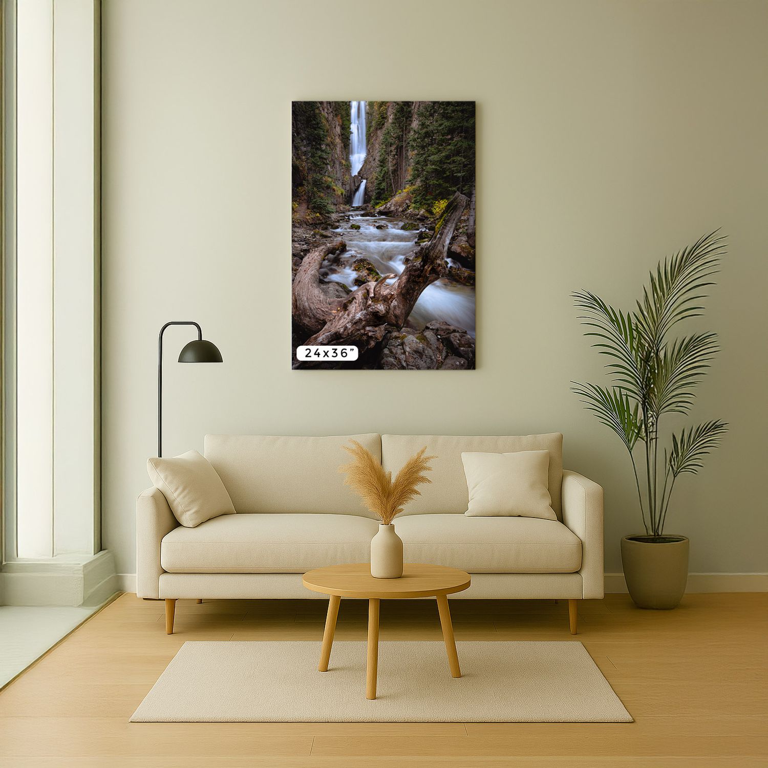 Modern living room interior with a large waterfall nature photography canvas print, beige sofa and potted palm plant.