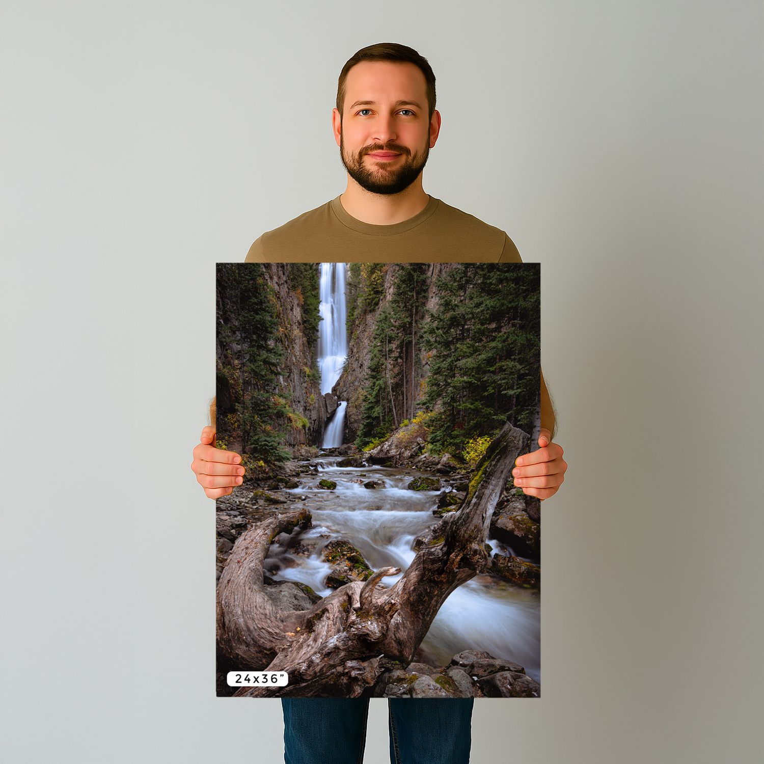 Someone holding a nature photography print showing Latourell Falls cascading down moss-covered cliffs in Oregon.