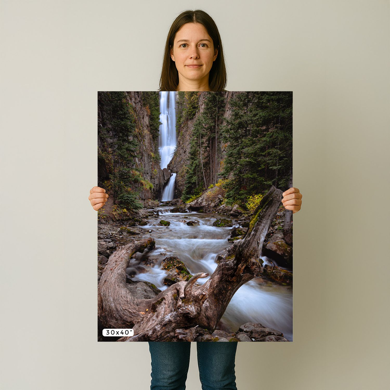 A scenic waterfall print showing cascading water over rocks in a lush forest scene with a fallen log in the foreground.