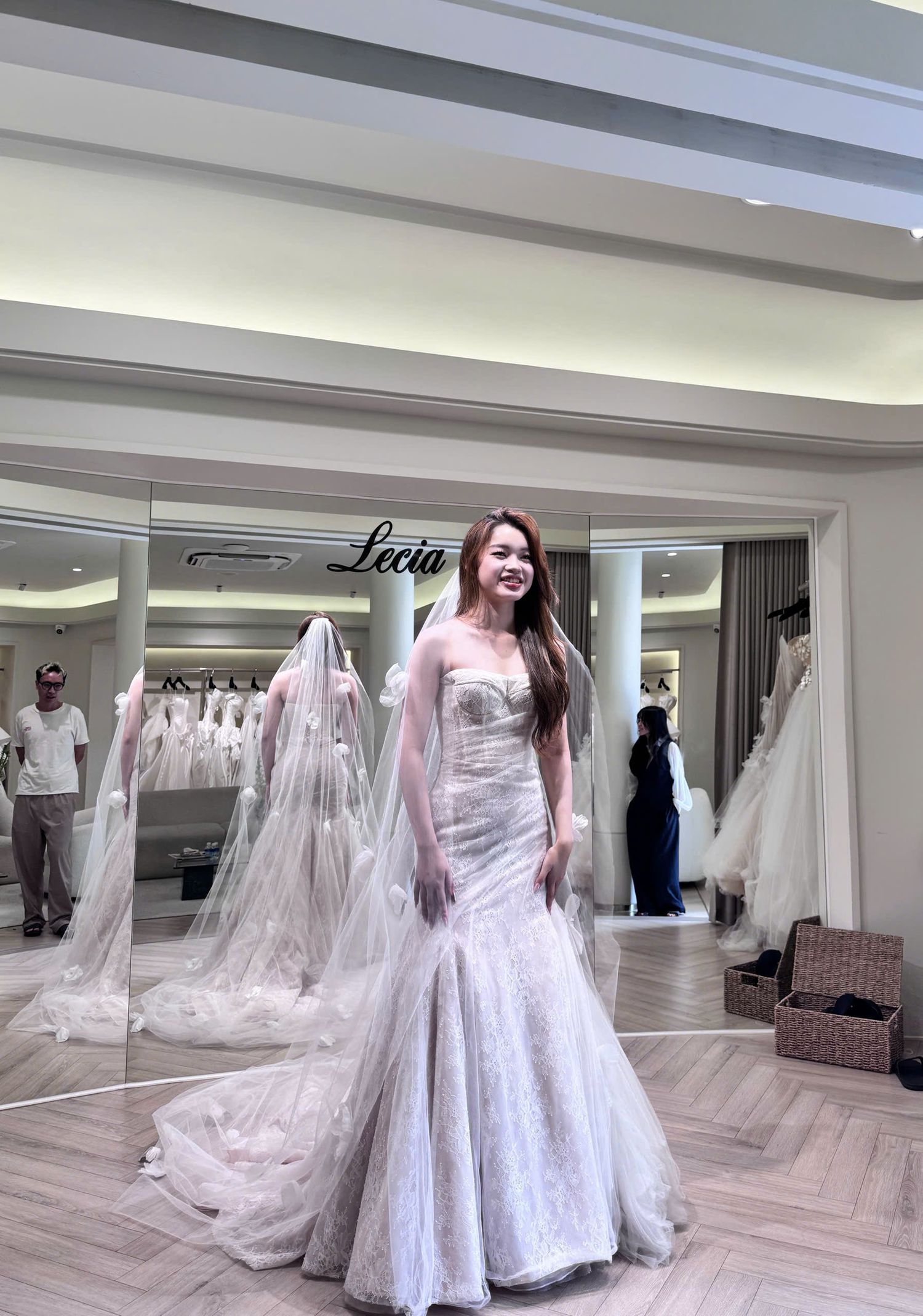 Bride in a strapless mermaid lace wedding gown with veil at the Lecia bridal boutique.