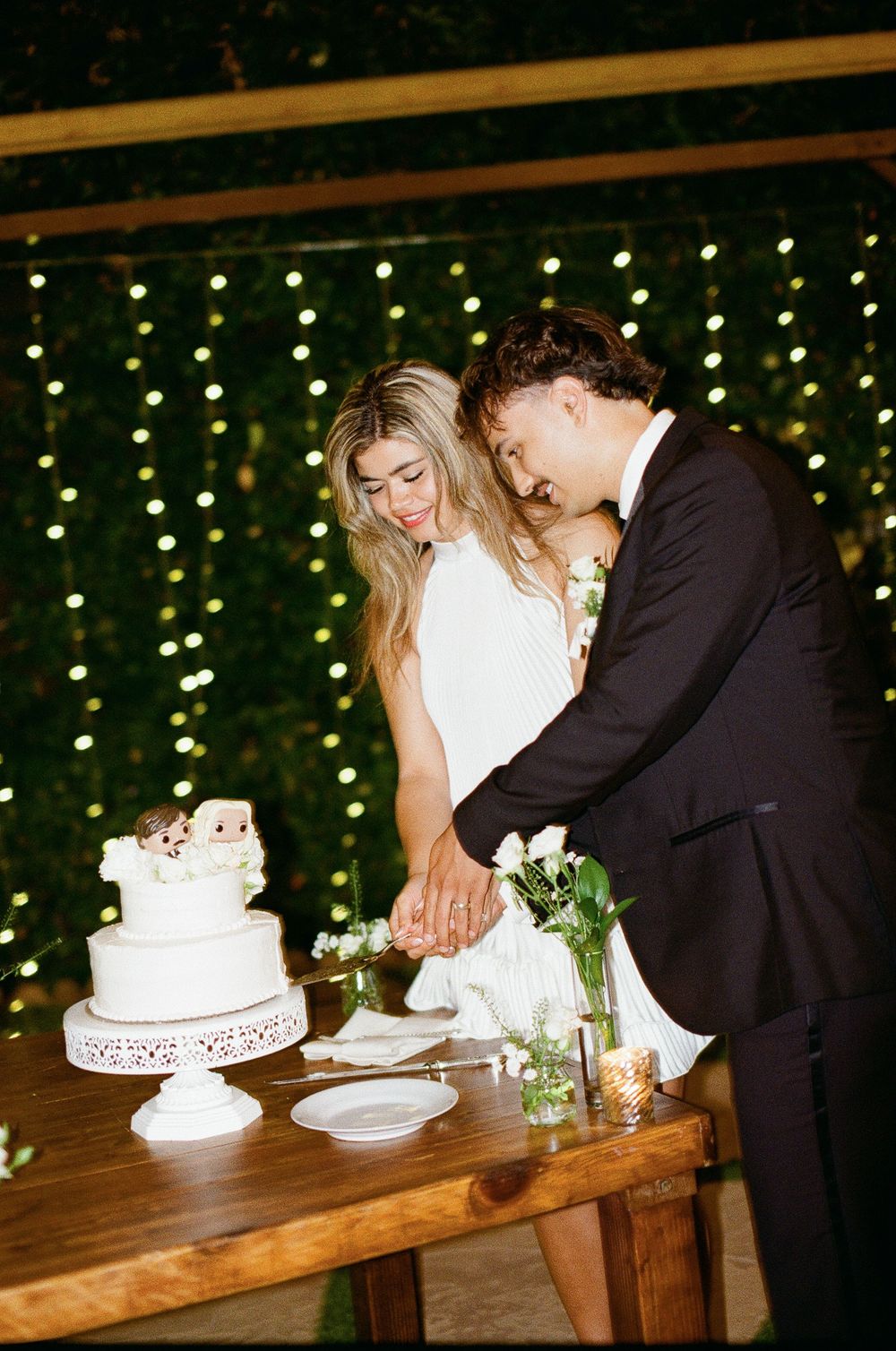 A couple cuts their wedding cake at a fun flash wedding reception on film photography