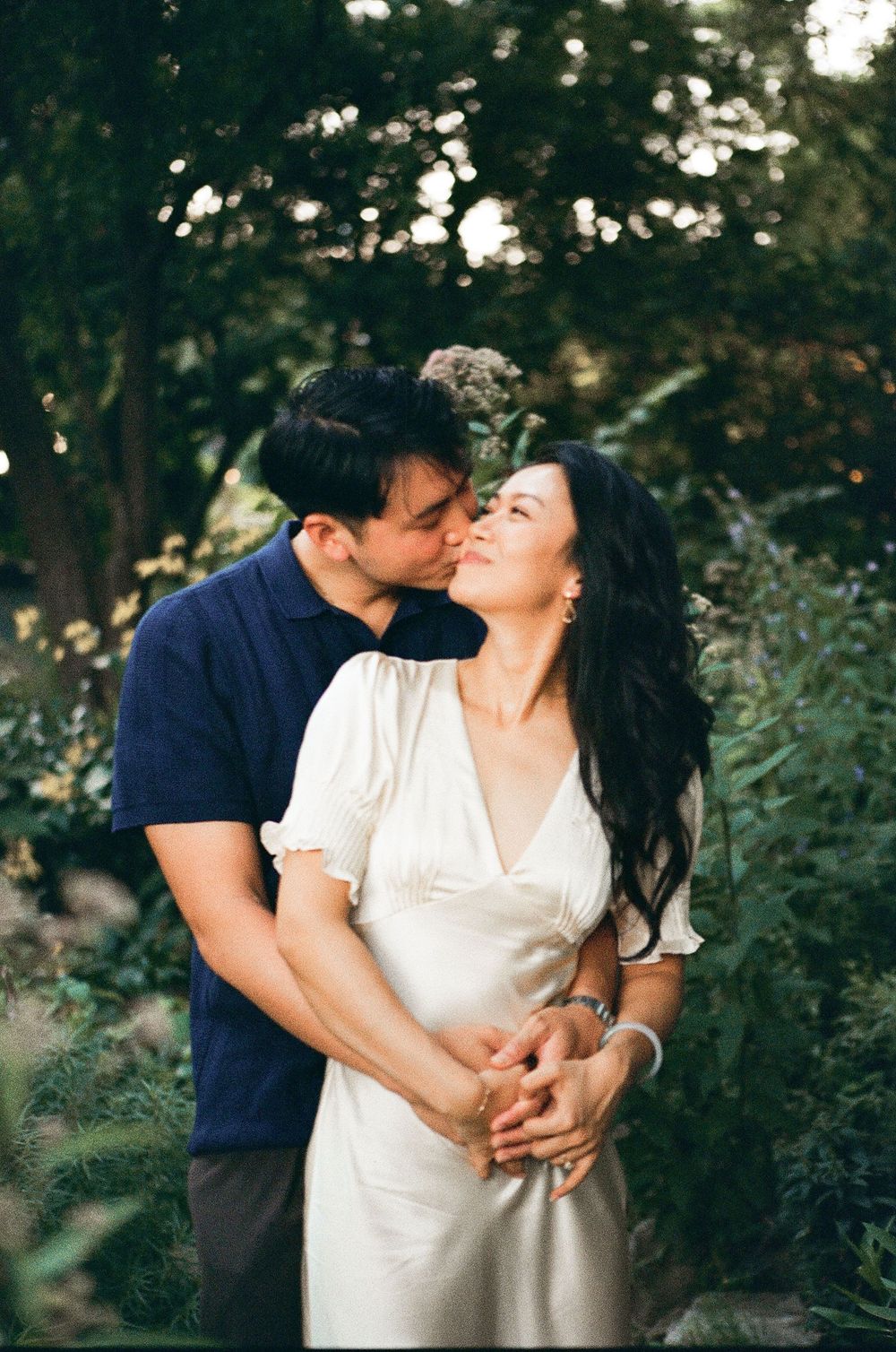 McGill Rose Garden film photography shows a couple for engagement photos smiling in downtown Charlotte North Carolina