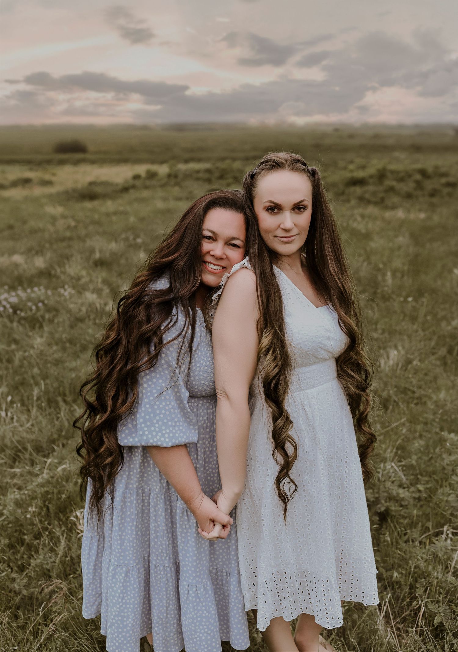 Adult sisters posing together during extended family portraits at Arbor Hills