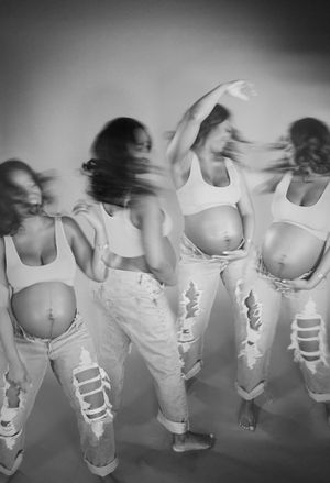 Motion blur photo of dancers in white tops and distressed jeans.