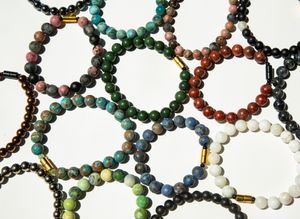 Colorful beaded bracelets arranged in an overlapping circular pattern.