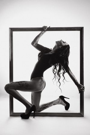 Artistic black and white photo of a dancer posing within a square frame.