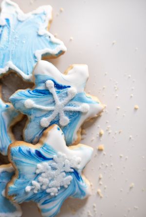 Decorative blue and white snowflake sugar cookies with royal icing on a light background.