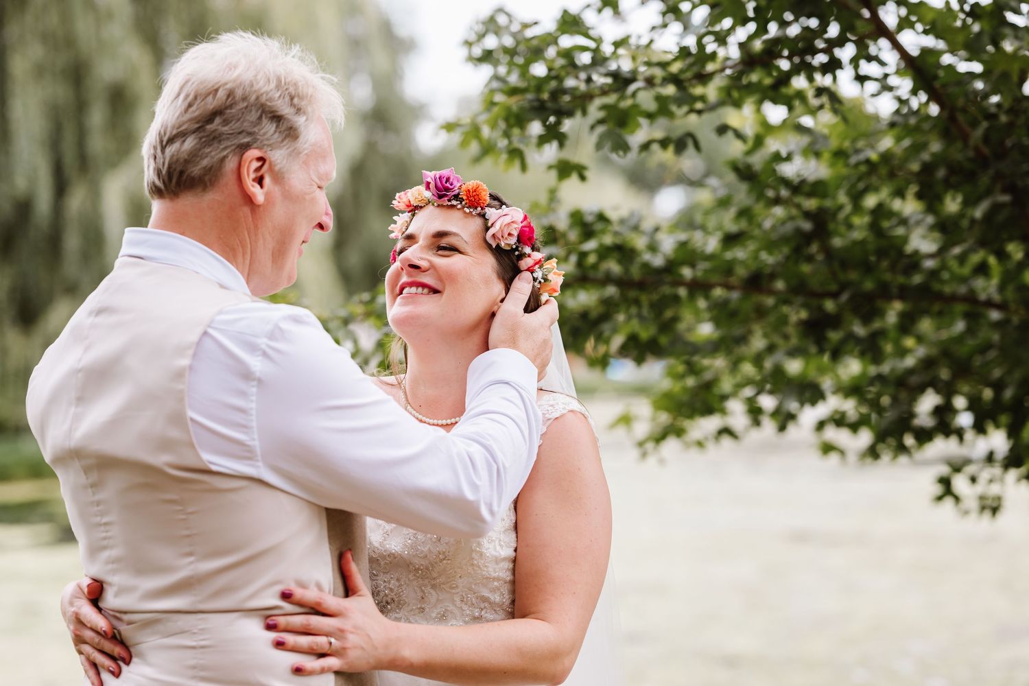 Bride and groom share a tender dance outdoors, bride wearing a floral crown, smiling joyfully. Waterside Country Barn, Taunton barn wedding