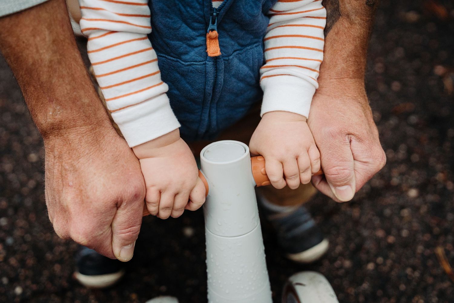 a father and sons hands on the bike handlebar during a lifestyle storytelling photography session