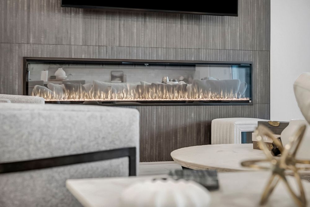 Close-up of a modern linear gas fireplace with flames, set in a sleek dark textured wall panel.