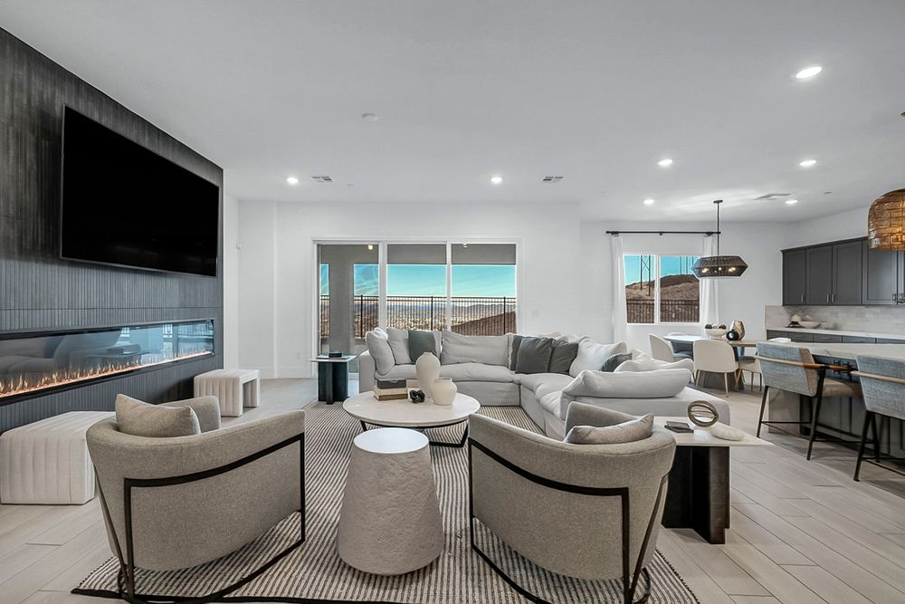Open-concept living room with linear fireplace, neutral furnishings, recessed lighting, and kitchen bar seating.