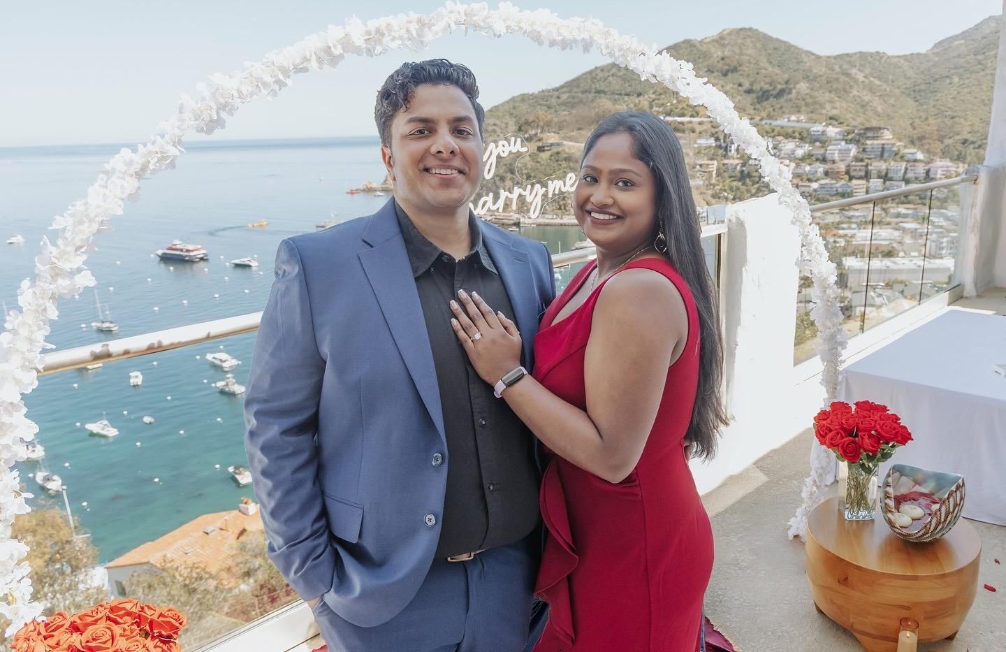 A couple embraces in formal attire during an outdoor portrait session with soft bokeh lighting in the background.