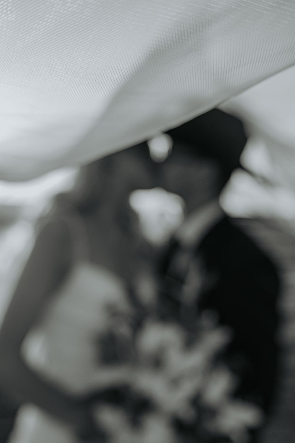 Abstract black and white photo with soft fabric draping creating blurred shadows and highlights.