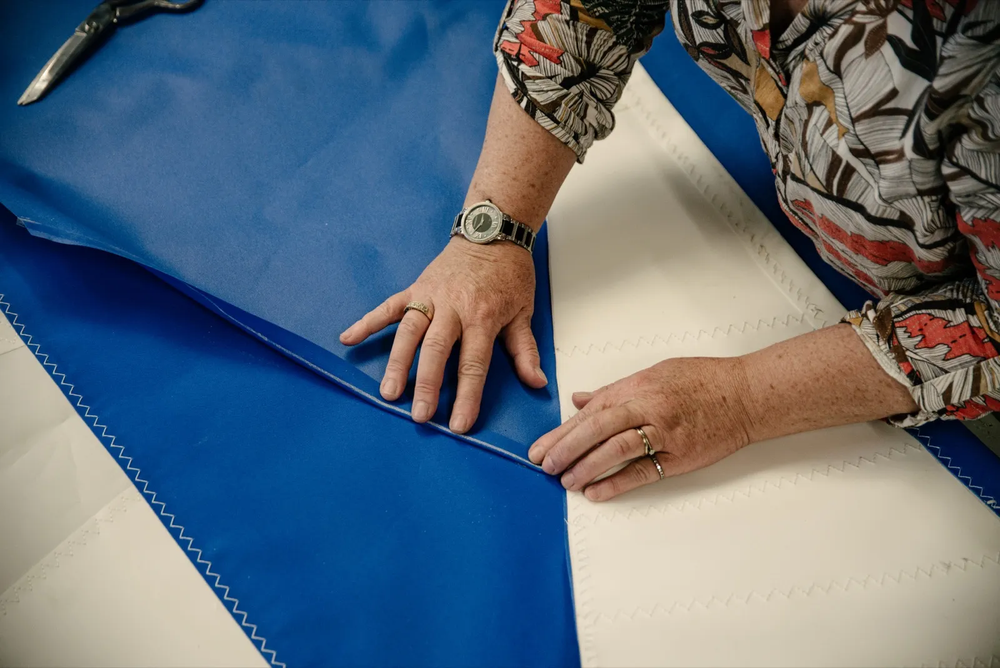 Mains travaillant sur une voile de bateau.