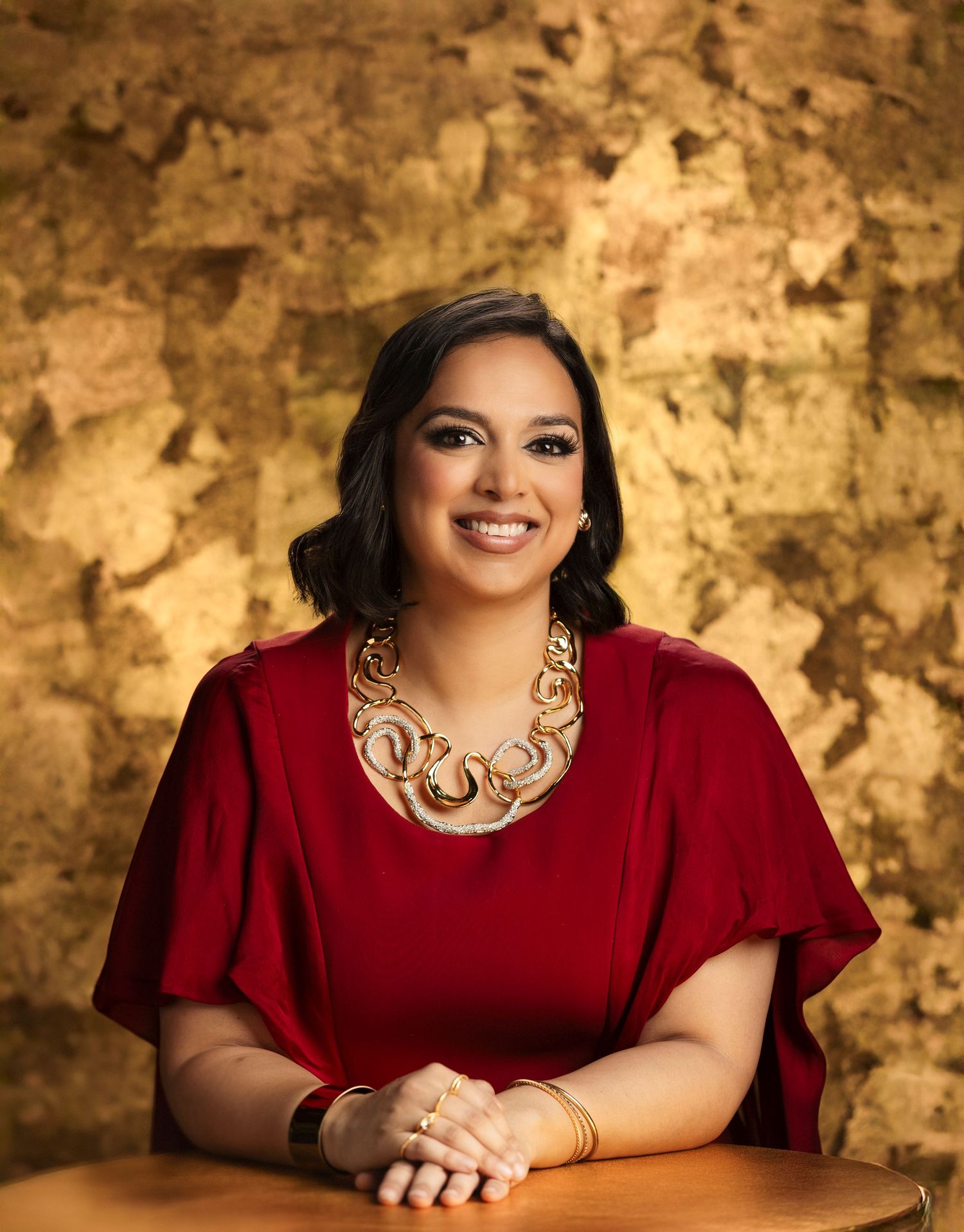 Portrait photo series in warm sepia tones featuring a woman in burgundy dress and statement necklace against textured backdrop.