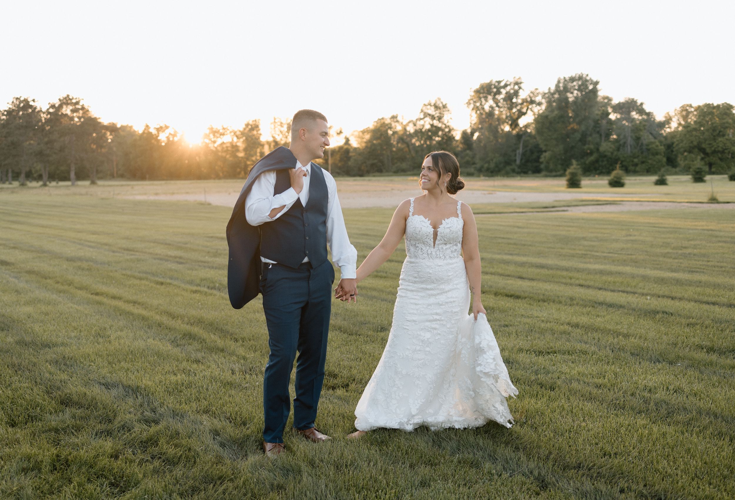 Golden hour wedding photo of bride and groom in field, taken by Ellie Rae Photography in La Crosse, Wisconsin