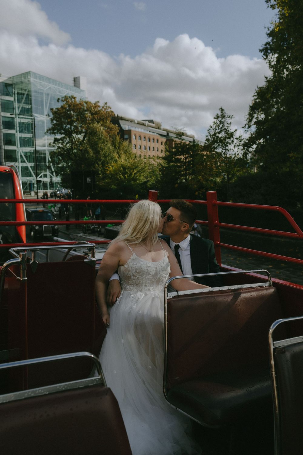 Newlyweds share a romantic moment on a sightseeing bus tour through the city.